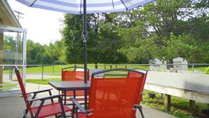 Picnic umbrella with table and chairs in patio.